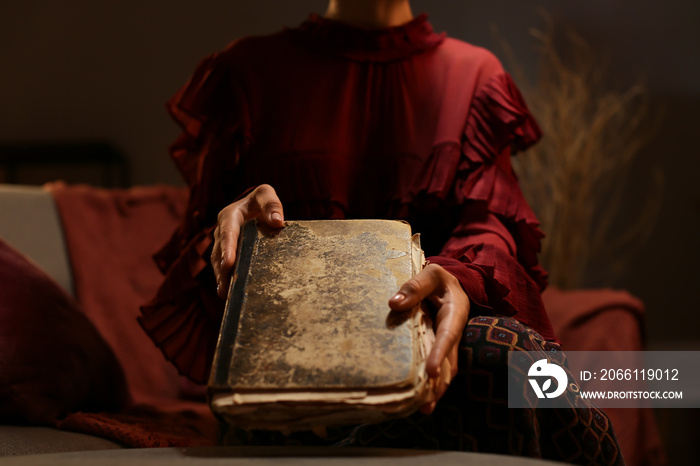 Beautiful woman with old book at home