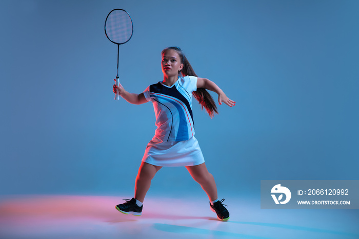 Energy. Beautiful dwarf woman practicing in badminton isolated on blue background in neon light. Lif