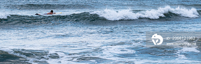 Man on surfboard between waves looking for a ride