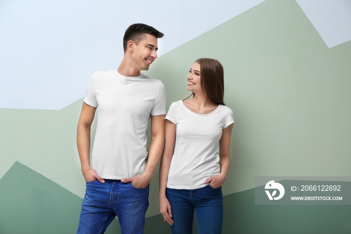 Young woman and man in white t-shirts on color background. Mockup for design