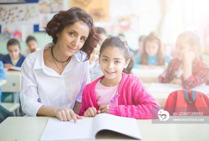 teacher and student looking at camera in the classroom and smiling