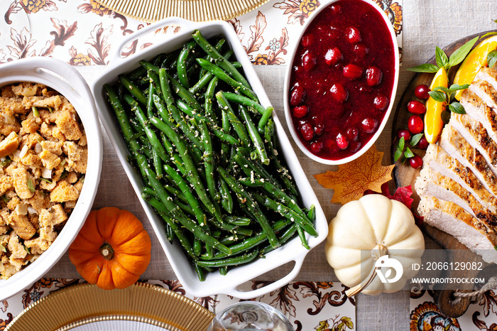 Thanksgiving dinner table with sliced turkey and sides, overhead shot