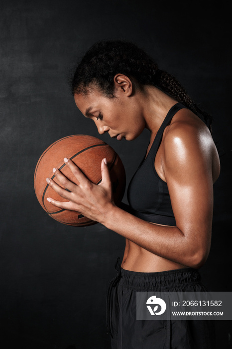 穿着运动服拿着篮球的美丽非裔美国女性形象