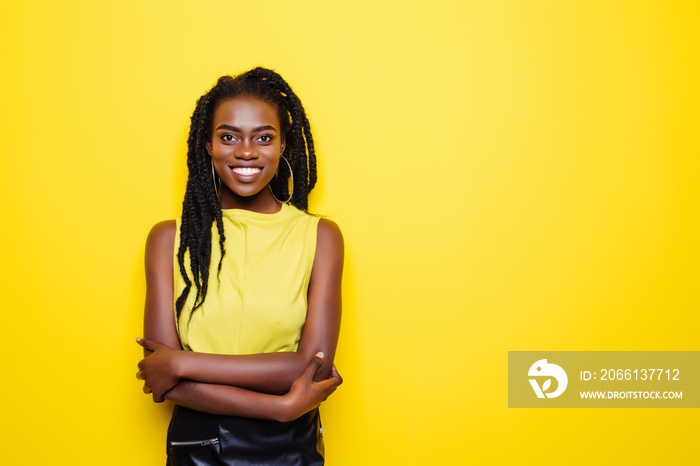 Portrait of smiling woman with dreadlocks in yellow blouse