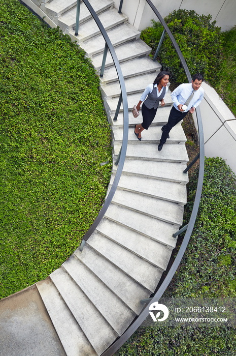 High angle view of business people descending spiral stairway