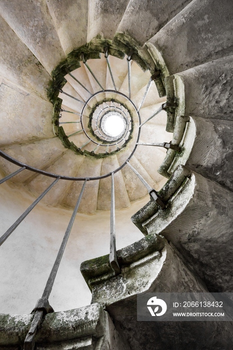 一个古老的石头螺旋楼梯从地面向上射出，形成一个金色的螺旋