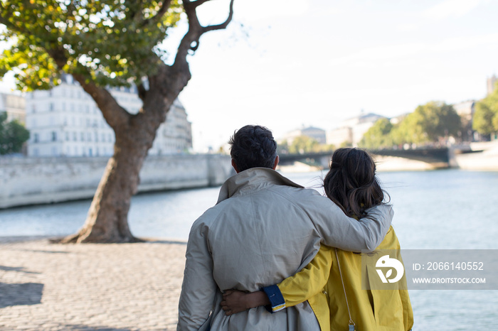 Affectionate couple walking along Seine River, Paris, France