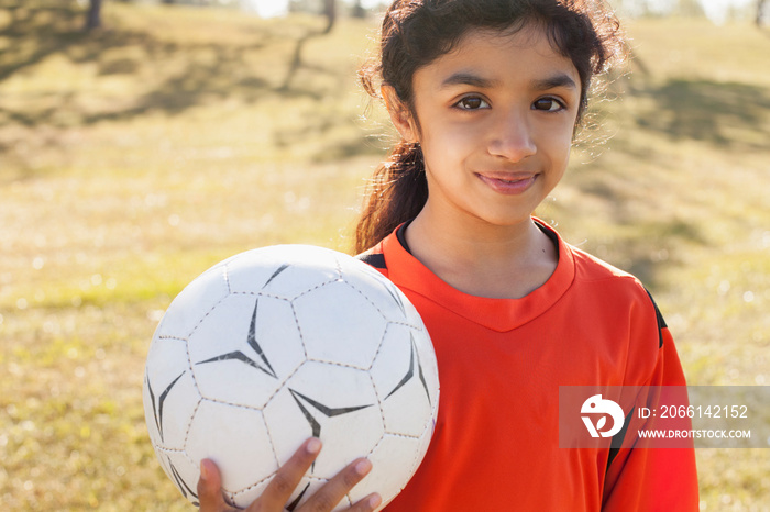 Girl soccer player holding soccer ball