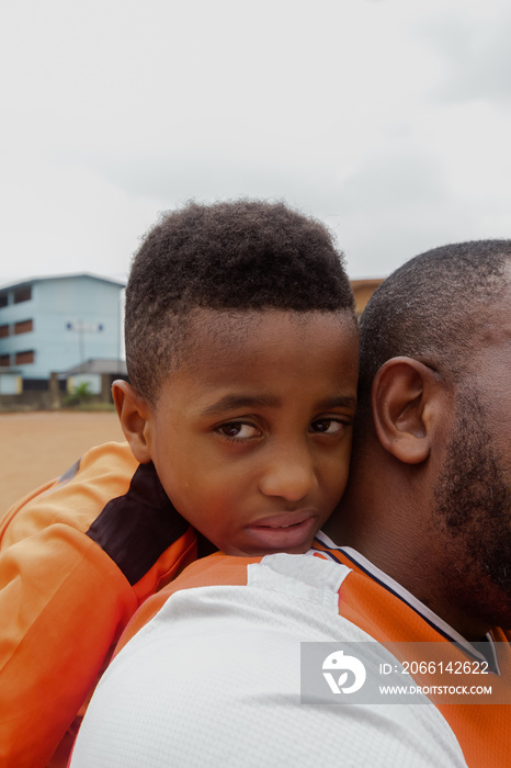 Son resting head on fathers shoulder