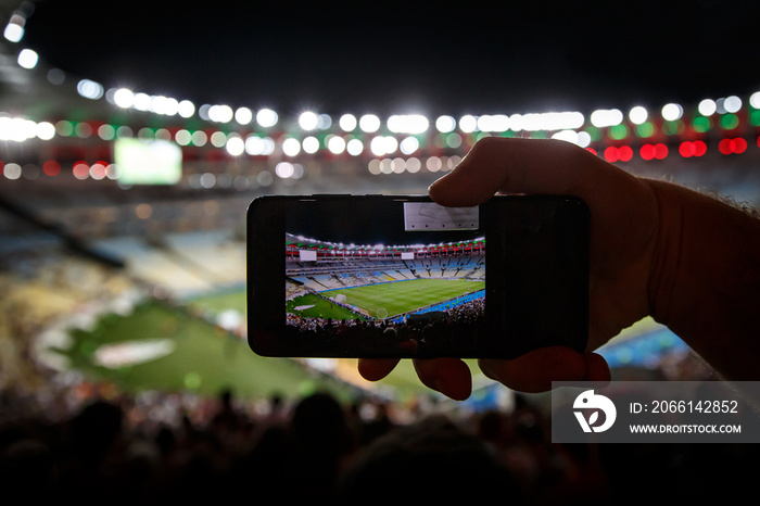 Using a smartphone on soccer stadium.