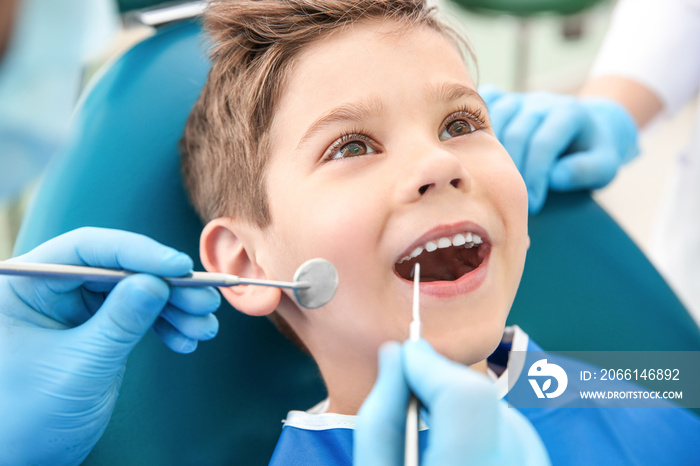 Dentist examining little boys teeth in clinic