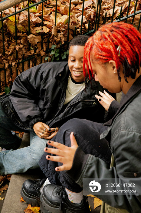 A black trans masculine person painting their friend nails.