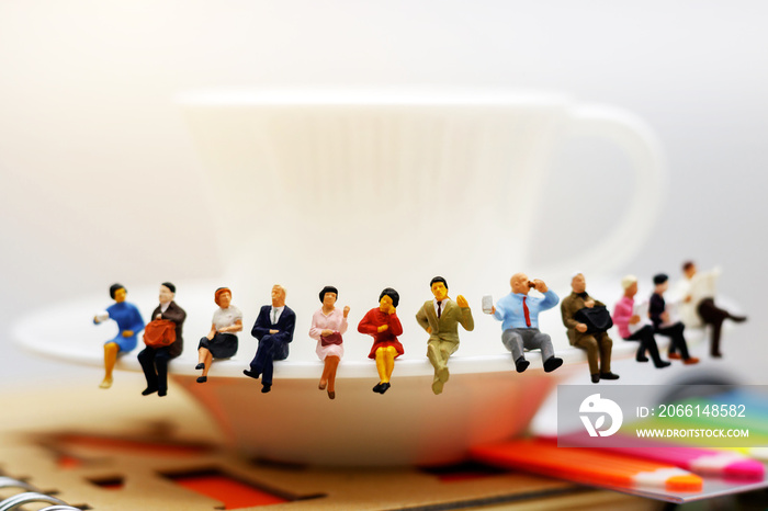 Miniature people: business team  sitting on cup of coffee,  break time of business concept.