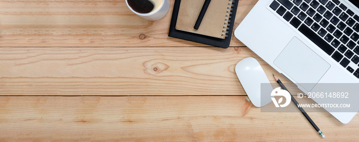 Top view of blank screen smart phone on wooden office desk with coffee cup, keyboard, supplies and c