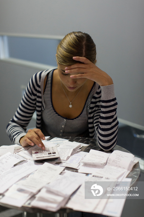 Focused female accountant calculating receipts in office