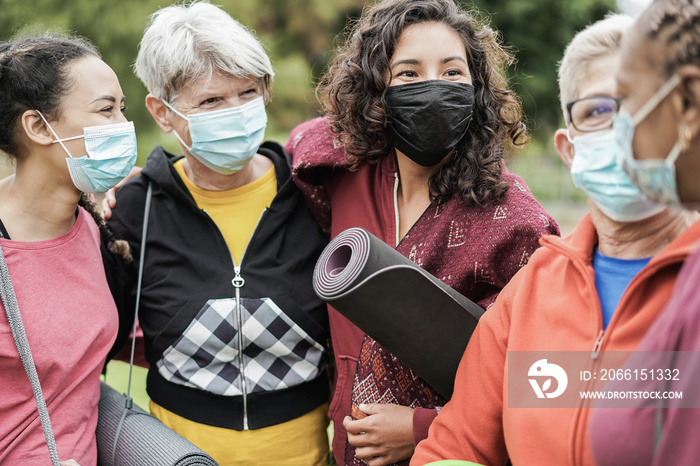 Multi generational women having fun before yoga class wearing safety masks during coronavirus outbre