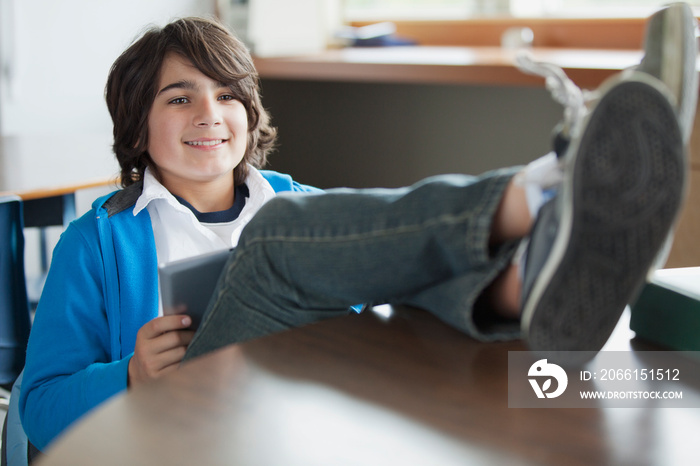 Male student with computer and feet up on desk