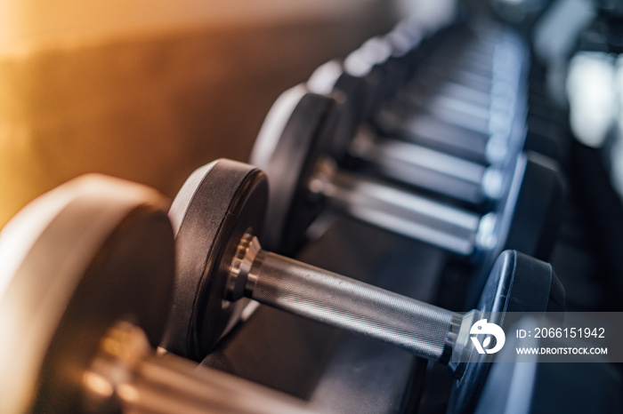 Rows of dumbbells in the gym with hign contrast and vintage color tone.