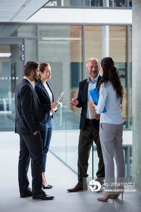 Businesspeople having a discussion in office corridor