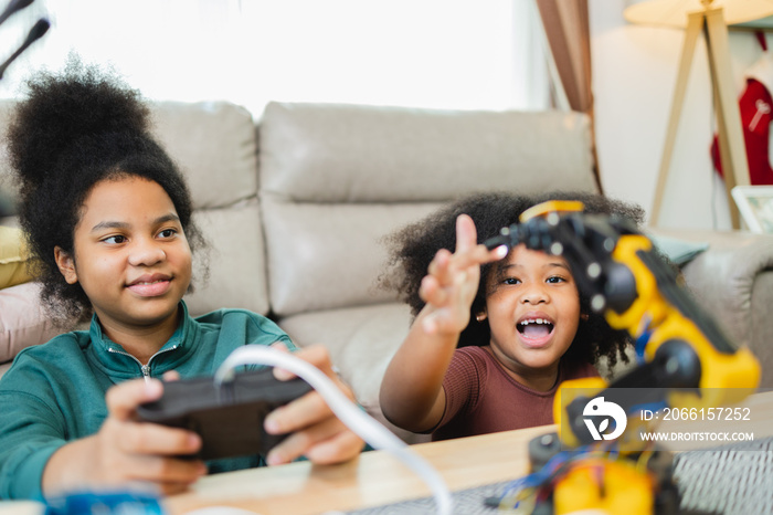 Two African American girls learned robot arms with a program computer. Innovative technology mechani