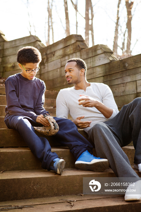 Father and son (10-11) sitting on steps