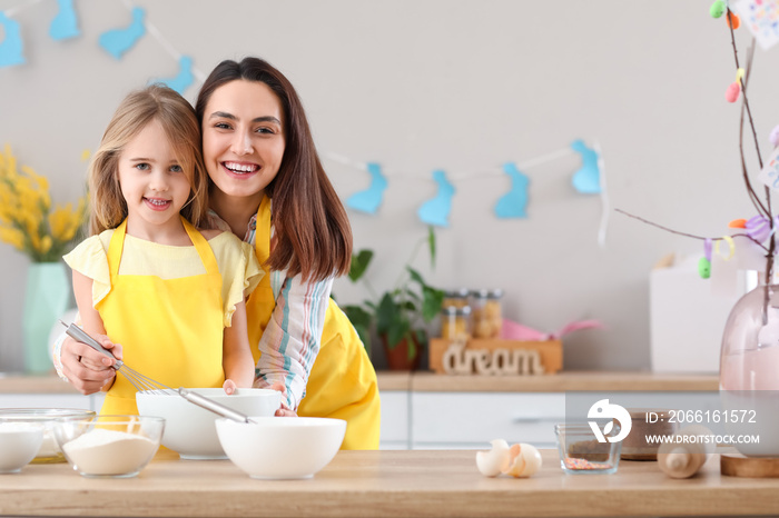 Little girl with her mother preparing dough for Easter cake in kitchen