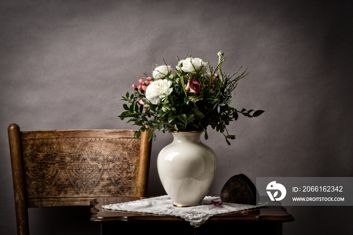 roses in the vase wither on old side table