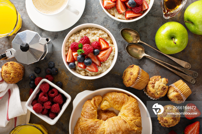 Breakfast table with oatmeal porridge, croissants and muffins