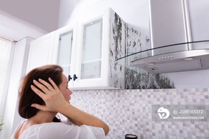 Woman Looking At Mold On Wall