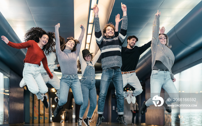 Happy young friends having fun jumping in subway underground metropolitan - Youth millennial friends