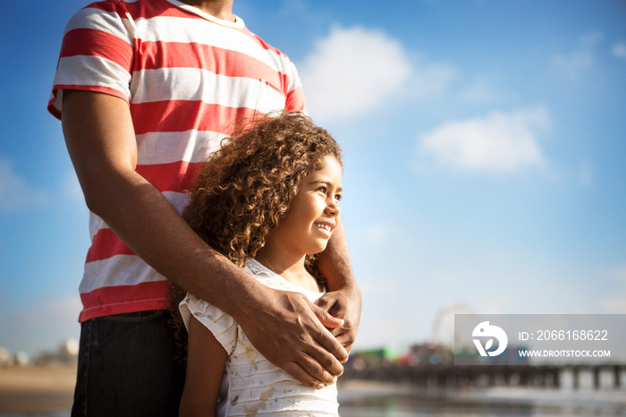 Girl standing with father outdoors