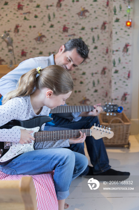 Father and daughter playing electric guitars