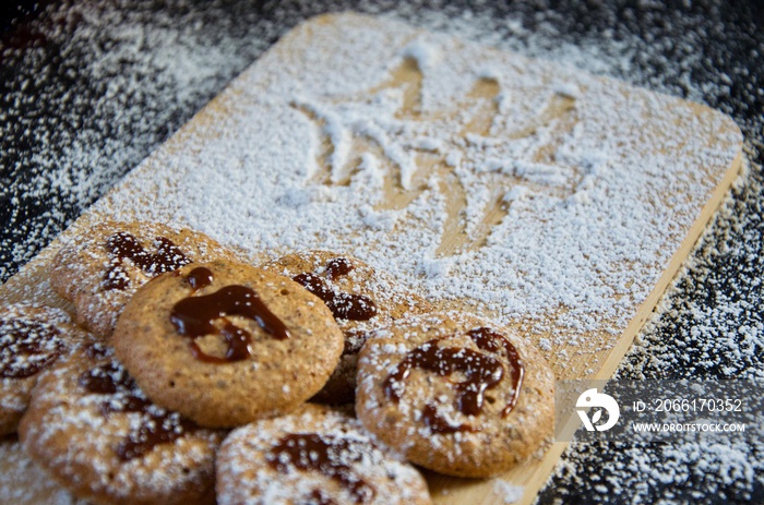 Traditional homemade german hazelnut Christmas cookies with chocolate topping on a wooden board, cov