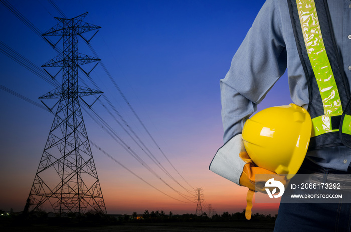 Engineer holding yellow helmet with Transmission tower.