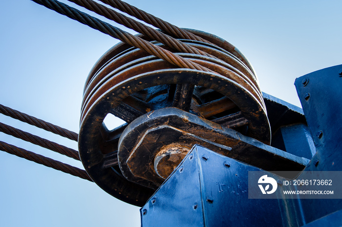 Three cable metal pulley wheel with cables.