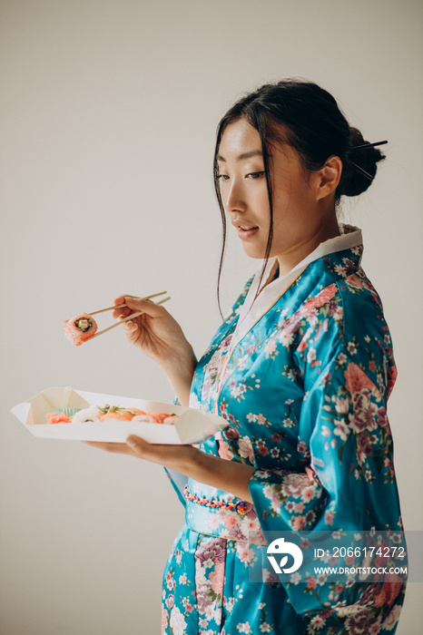 穿着和服吃寿司卷的女人