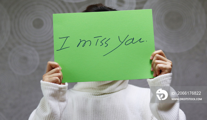 Woman wearing a white sweater, handwritten letter, I miss you