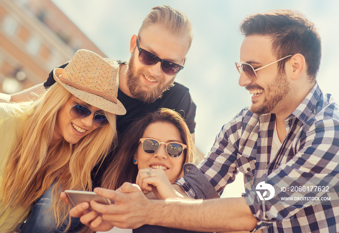 Group of four happy friends taking selfie