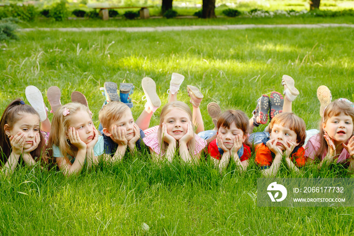 a group of children playing and running in the park on a green gozon.