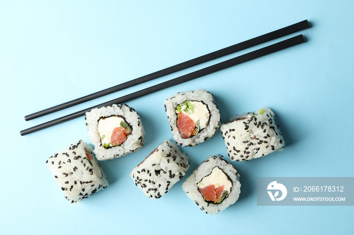 蓝色背景的筷子和寿司卷。日本食品