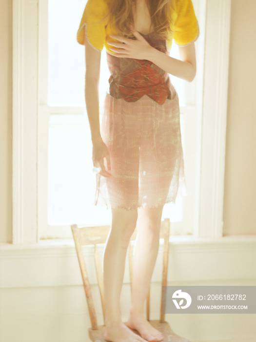 Low-section of woman standing on chair