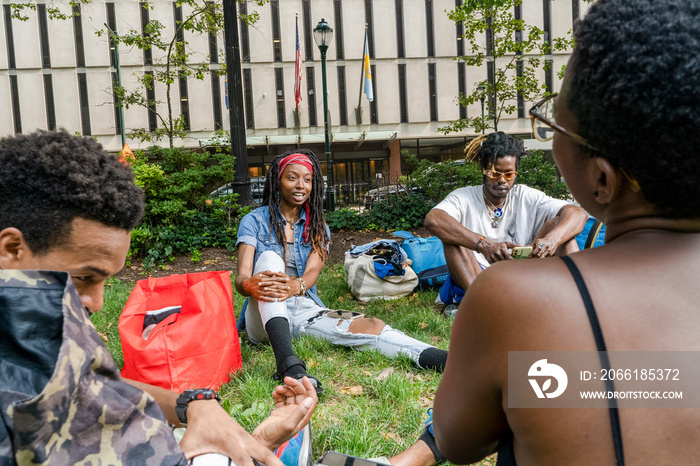 USA, Group of young friends relaxing on lawn in park