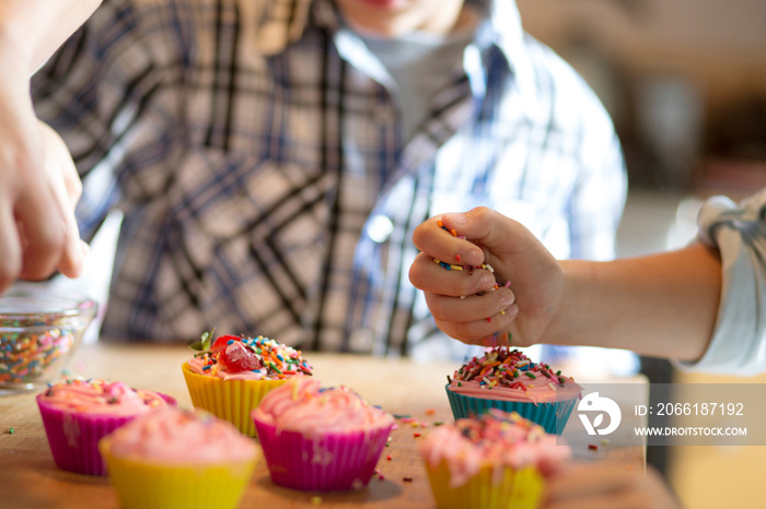 Children (6-7) making cupcakes