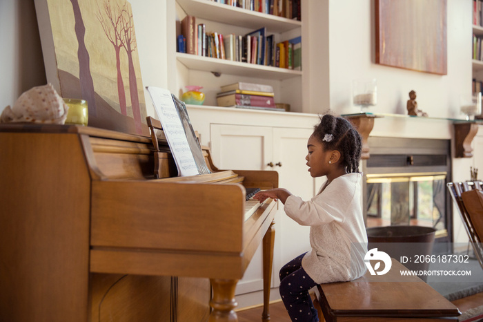 Girl (2-3) playing on piano