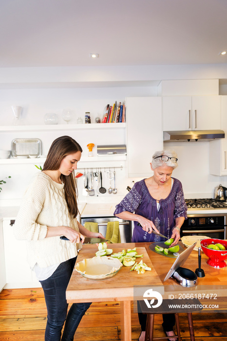 Two women cooking together in kitchen