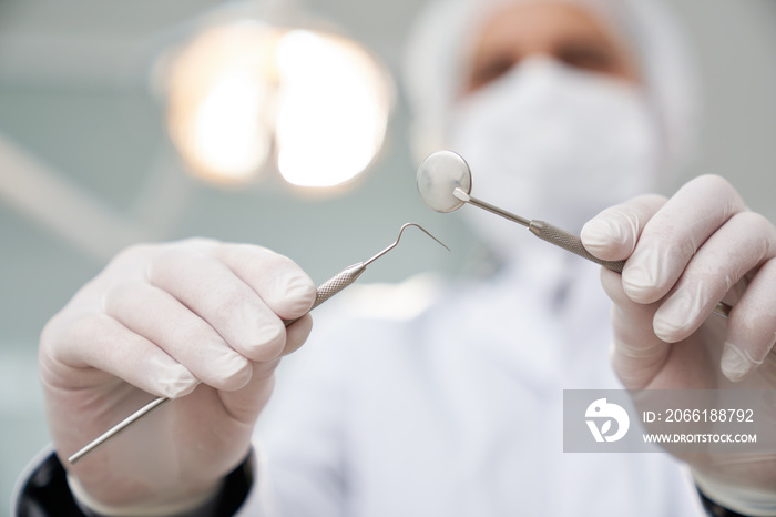 Dentist in medical cap and mask looking at patient.