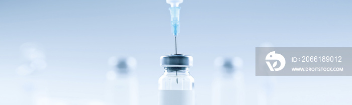 Medical syringe with a needle and a bollte with vaccine.