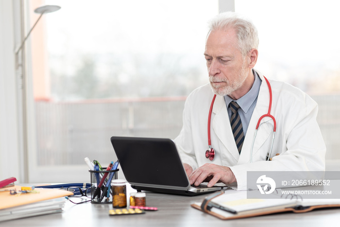 Senior doctor using laptop