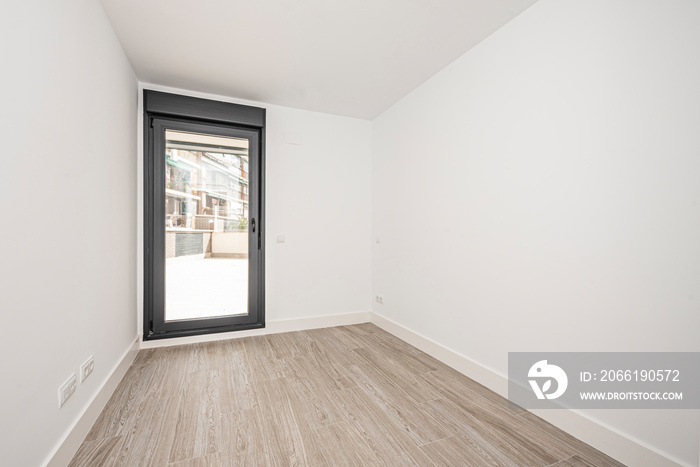 Empty room with glass door and black aluminum frame leading to a terrace