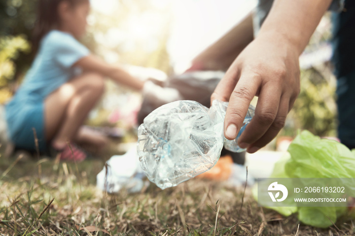 woman hand picking up trash bottle for cleaning at park